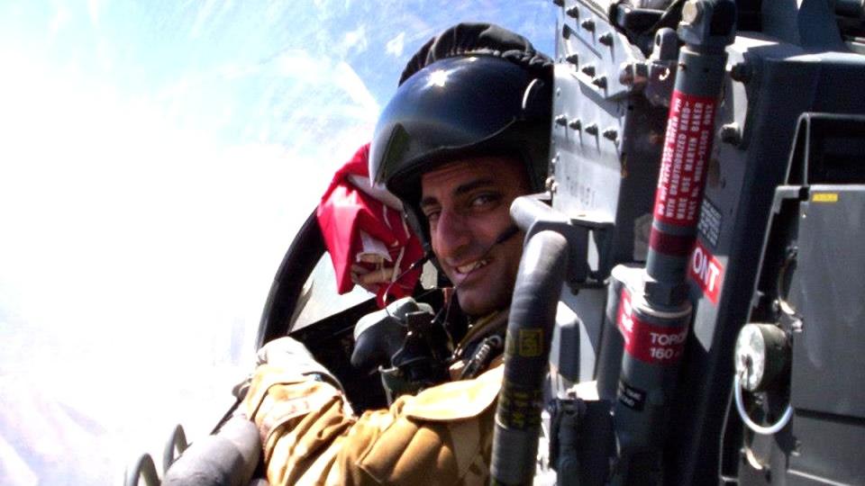 an astronaut in a jet cockpit looking over his shoulder in mid-flight