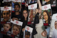 Relatives of people kidnapped by Hamas militants hold the pictures of their loved ones during a protest in Tel Aviv, on Saturday, Oct. 21, 2023. Relatives of people kidnapped by Hamas militants and supporters organise a protest calling for the return of more than 200 hostages held in Gaza for two weeks. (AP Photo/Petros Giannakouris)