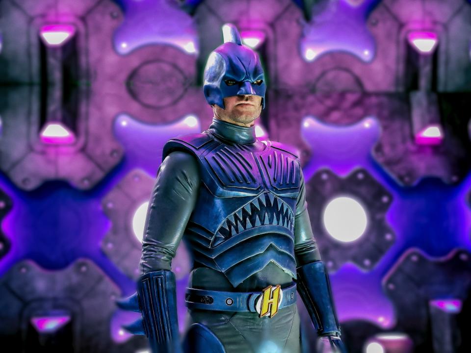boy in superhero suit against purple background