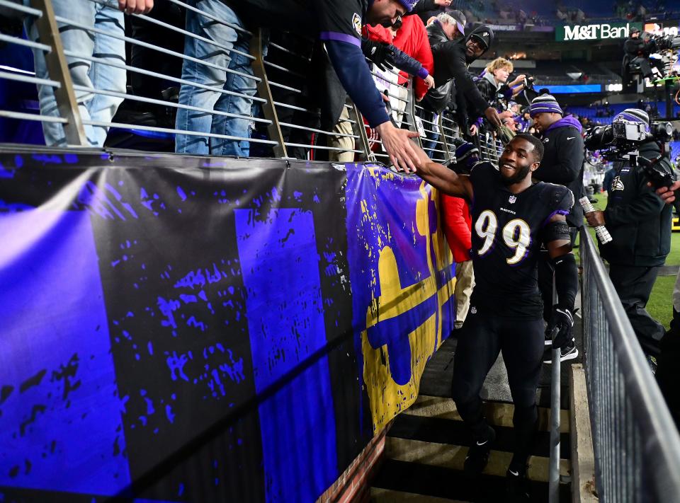 Baltimore Ravens outside linebacker Odafe Oweh (99) high fives fans after beating the Cleveland Browns 16-10 at M&T Bank Stadium.