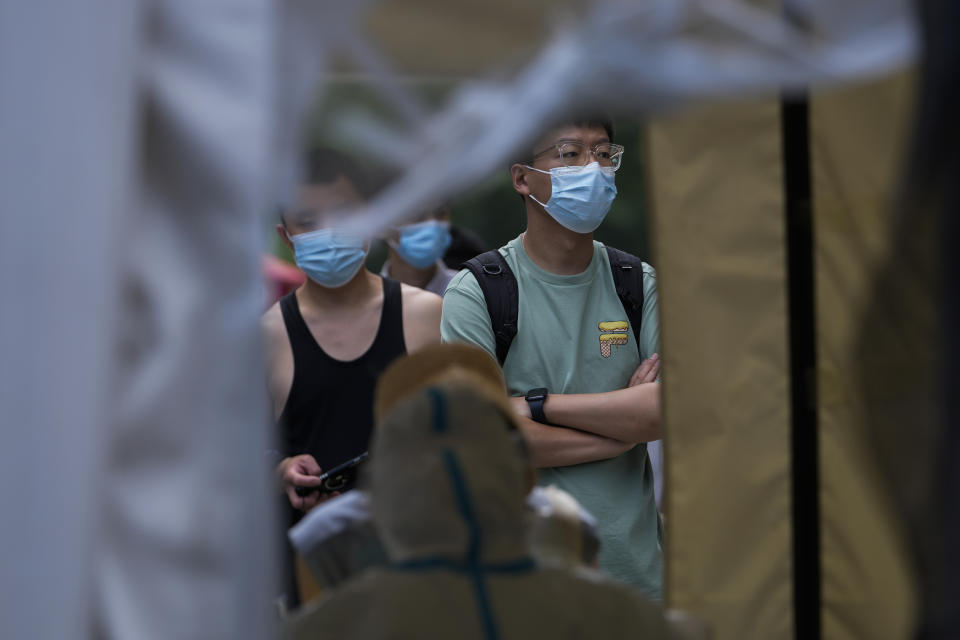 Residents line up to tested for COVID-19 at a testing site in the Chaoyang district in Beijing, Tuesday, June 14, 2022. Authorities ordered another round of three days of mass testing for residents in the Chaoyang district following the detection of hundreds coronavirus cases linked to a nightclub. (AP Photo/Andy Wong)