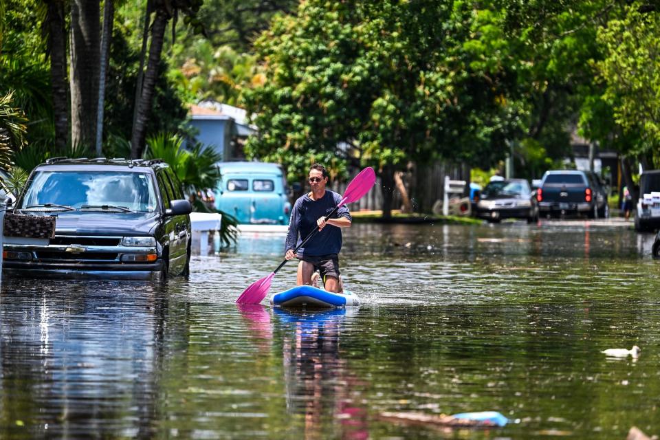 A person using a paddle to float on the water with what looks like a surfboard