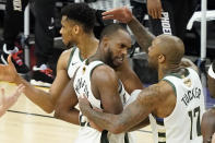 Milwaukee Bucks' Giannis Antetokounmpo, from left, celebrates with Khris Middleton and P.J. Tucker during the second half of Game 5 of basketball's NBA Finals against the Phoenix Suns, Saturday, July 17, 2021, in Phoenix. (AP Photo/Matt York)