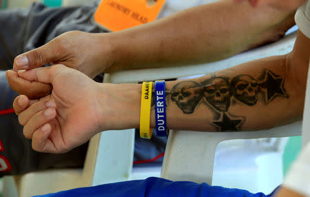 A drug user undergoing rehabilitation wears wrist bands with the name of Philippines' President Rodrigo Duterte while reciting prayers as part of his regular activities at the Center for Christian Recovery in Antipolo, Philippines September 12, 2016. REUTERS/Romeo Ranoco/File Photo