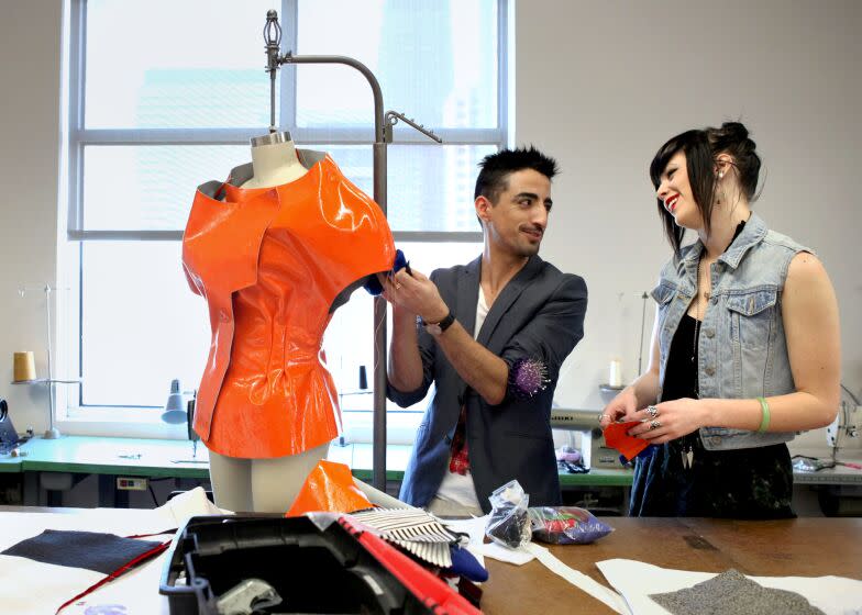 LOS ANGELES, CA: December 5, 2011 - Alejandro Ortega, left, talks with Jessica Dunn, both students, as he works on making his pieces for the Fashion Institute of Design & Merchandising's (FIDM) annual DEBUT Runway Show. Each student has to make ten different "looks" for the show. (Katie Falkenberg / For The Times)