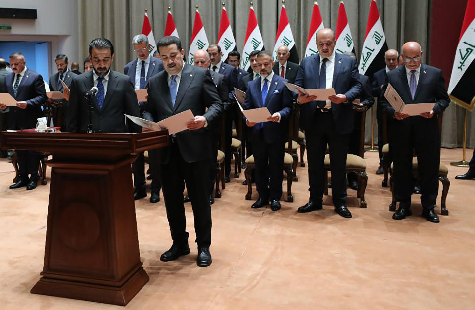 This photo provided by Iraqi Parliament Information Office, ministers of the new Iraqi government are sworn in during the parliamentary session to vote on the new government in Baghdad, Iraq, Thursday, Oct. 27, 2022 (Iraqi Parliament Information Office via AP)