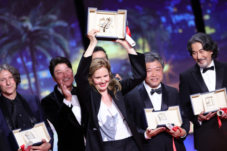CANNES, FRANCE - MAY 27: (L-R) Justine Triet (M) receives The Palme D'Or Award for 'Anatomy of a Fall' during the closing ceremony during the 76th annual Cannes film festival at Palais des Festivals on May 27, 2023 in Cannes, France. (Photo by Andreas Rentz/Getty Images)