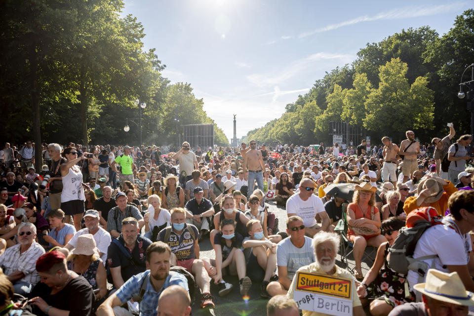 Protestors sit on the ground after the police declared the end of a protest, in Berlin, Germany, Saturday, Aug. 1, 2020. Thousands converged in Berlin to protest Germany's coronavirus restrictions at a demonstration proclaiming “the end of the pandemic” has arrived. The protest comes as German authorities are voicing increasing concerns about an uptick in new infections. (Christoph Soeder/dpa via AP)