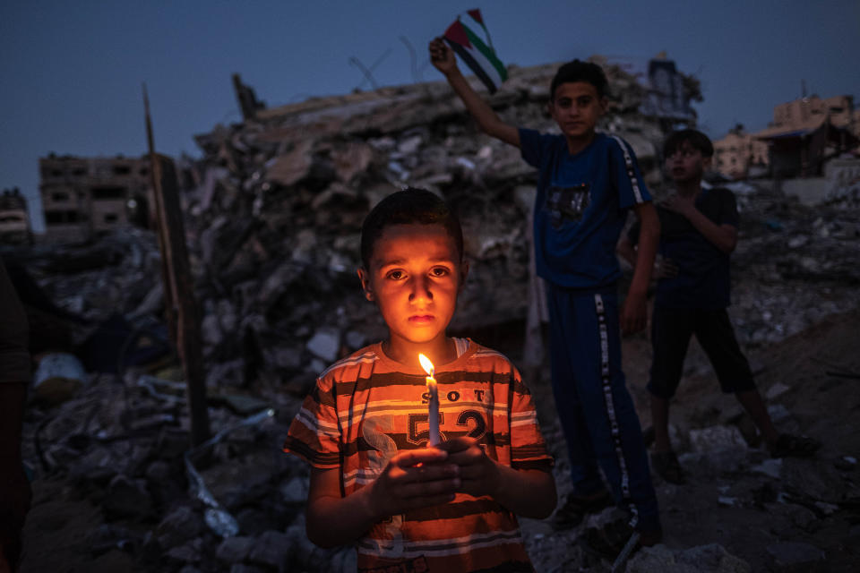 Palestinian children hold candles during a vigil Tuesday amid the ruins of houses in Beit Lahia, Northern Gaza Strip. Gaza residents returned to damaged and destroyed homes as the cease-fire between Israel and Hamas appeared to be holding.  (Photo: Fatima Shbair/Getty Images)