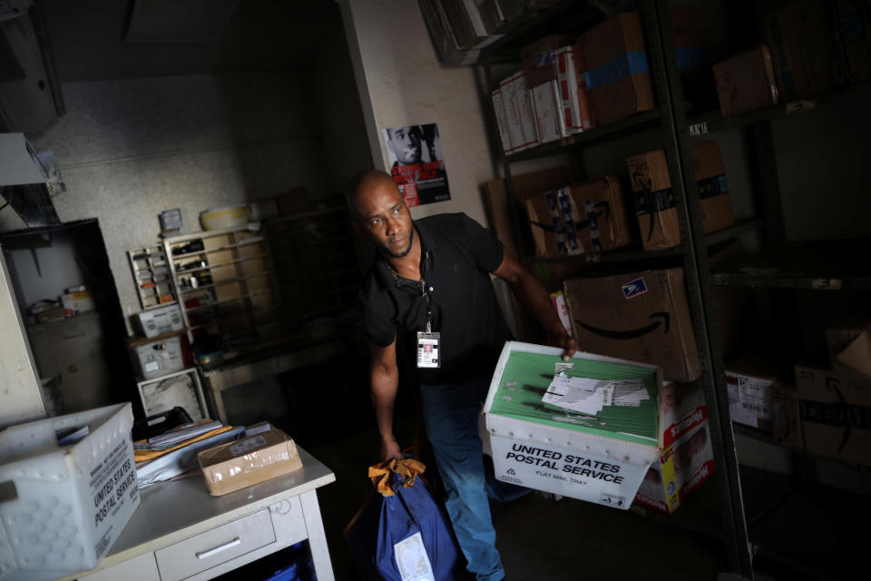 <p>Juan Rivera, from the U.S. Postal Service, picks up the mail at an area affected by Hurricane Maria in the island of Culebra, Puerto Rico, Oct. 7, 2017. (Photo: Carlos Barria/Reuters) </p>