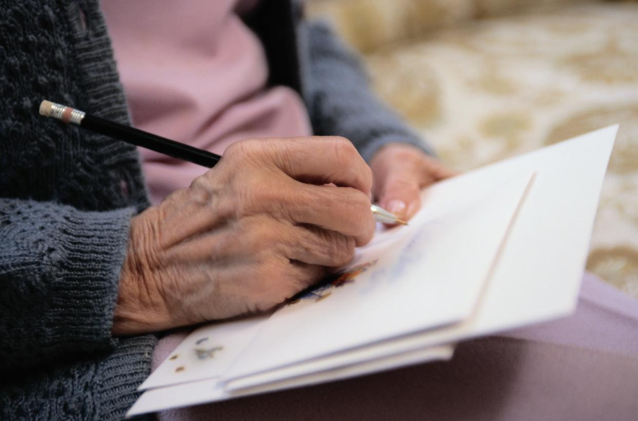 stock image of elderly hand writing on a card