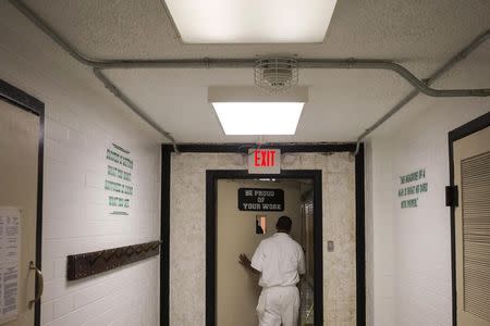 An offender pushes the door open to leave the cafeteria located in the Darrington Unit of the Texas Department of Criminal Justice men's prison in Rosharon, Texas August 12, 2014. REUTERS/Adrees Latif