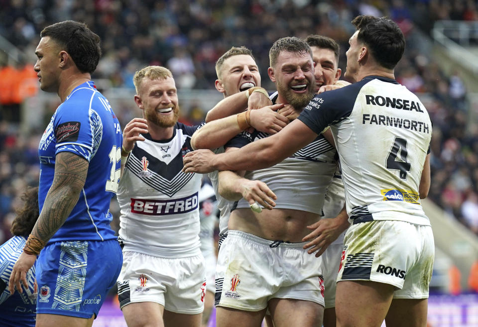 England's Elliott Whitehead, second right, celebrates with teammates after scoring his side's sixth try, during the Rugby League World Cup group A match between England and Samoa, at St James' Park, in Newcastle upon Tyne, England, Saturday, Oct. 15, 2022. (Owen Humphreys/PA via AP)