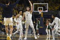 Michigan center Hunter Dickinson (1) reacts after making a 3-point basket as time expired in the first half of an NCAA college basketball game against Ohio, Sunday, Nov. 20, 2022, in Ann Arbor, Mich. (AP Photo/Jose Juarez)