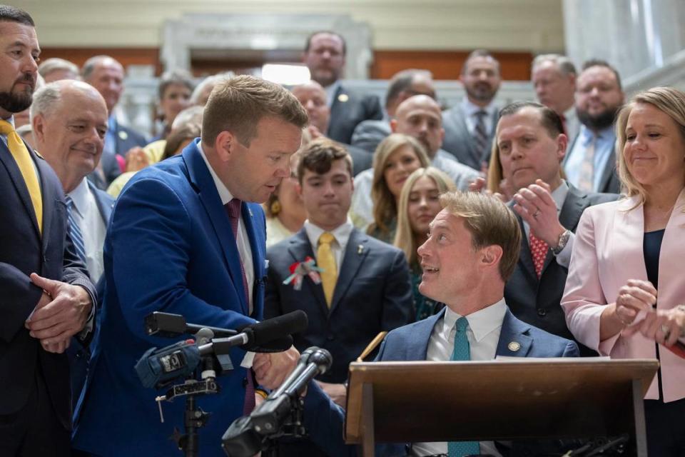 Kentucky state Rep. Jared Bauman, R-Louisville, standing, shakes hands with Kentucky Secretary of State Michael Adams before Adams signed House Bill 5, the Safer Kentucky Act, at the Kentucky state Capitol in Frankfort, Ky., on Monday, April 15, 2024. The bill, sponsored by Bauman, was vetoed by Gov. Andy Beshear before the legislature overturned the veto.