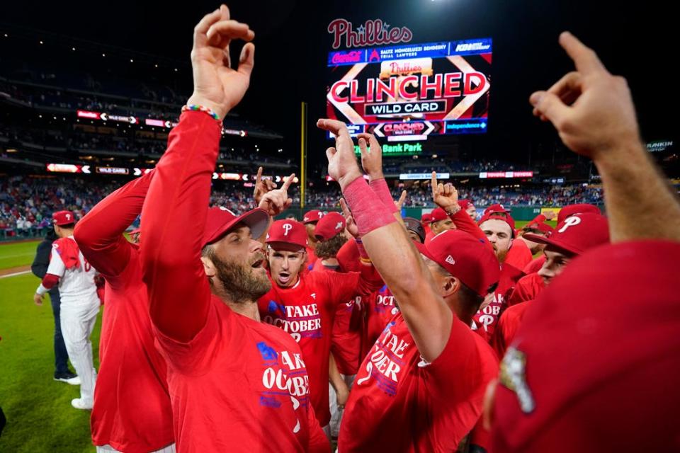 Philadelphia Phillies' Bryce Harper celebrates with teammates after their win in a baseball game against the Pittsburgh Pirates to clinch a wild-card playoff spot, Tuesday, Sept. 26, 2023, in Philadelphia.