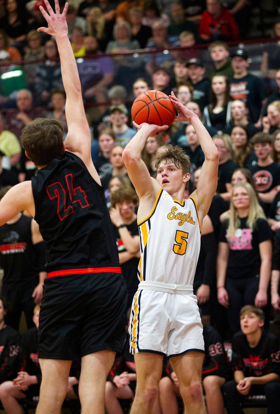 Colonel Crawford's Trevor Vogt shoots a 3-pointer over Seneca East's Lucas Hicks.