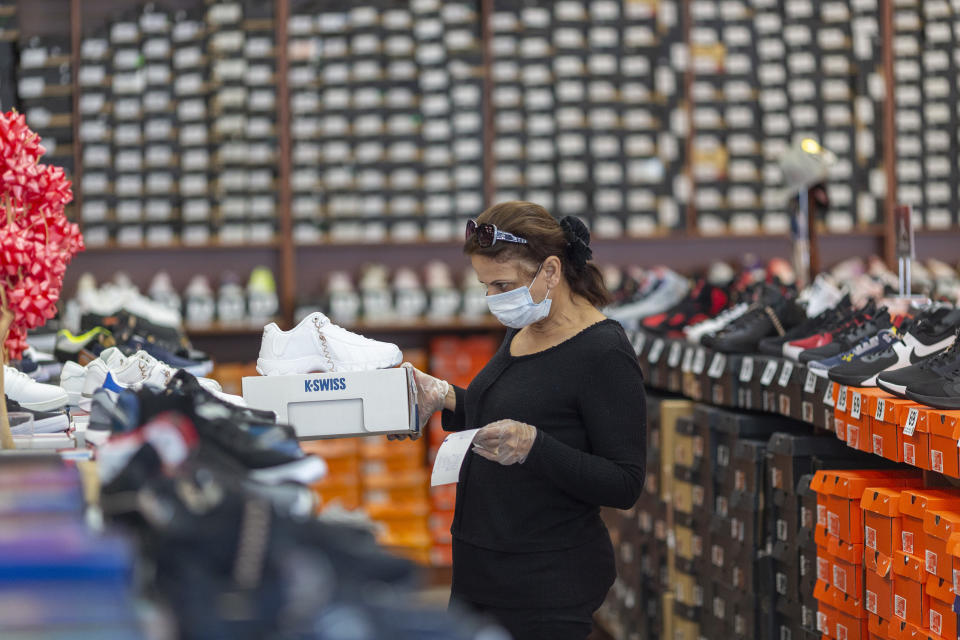 GLENDALE, CA - MAY 27: An employee stocks merchandise at a Shoe City store as Los Angeles County retail businesses reopen while the COVID-19 pandemic continues on May 27, 2020 in Glendale, Californias latest guidelines and allow the resumption of in-store shopping at low-risk retail stores, faith-based services, drive-in theaters and other recreational activities with reduced capacities and social distancing restrictions, starting today. Not reopening yet are personal services locations like hair salons and dining in at restaurants.  (Photo by David McNew/Getty Images)
