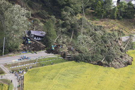 Police officers and rescue workers search for survivors from a building damaged by a landslide caused by a powerful earthquake in Atsuma town in Japan's northern island of Hokkaido, Japan, in this photo taken by Kyodo September 6, 2018. Mandatory credit Kyodo/via REUTERS ATTENTION EDITORS - THIS IMAGE WAS PROVIDED BY A THIRD PARTY. MANDATORY CREDIT. JAPAN OUT. NO COMMERCIAL OR EDITORIAL SALES IN JAPAN.