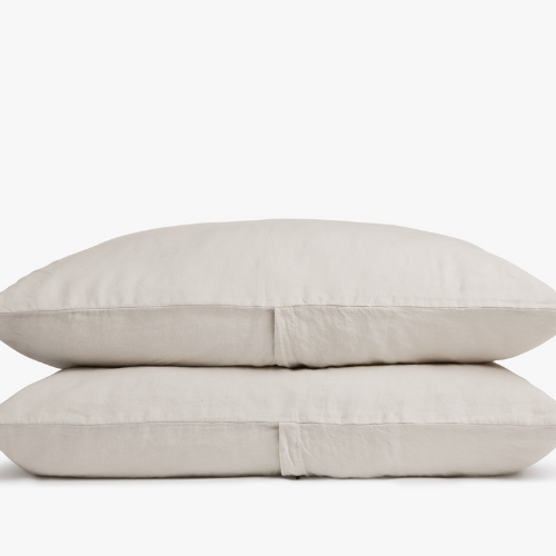 two pillows covered in beige linen pillowcases