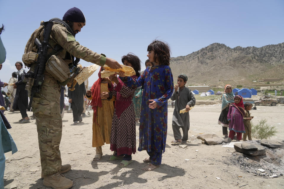 Afghans receive aid at a camp after an earthquake in Gayan district in Paktika province, Afghanistan, Sunday, June 26, 2022. A powerful earthquake struck a rugged, mountainous region of eastern Afghanistan early Wednesday, flattening stone and mud-brick homes in the country's deadliest quake in two decades, the state-run news agency reported. (AP Photo/Ebrahim Nooroozi)