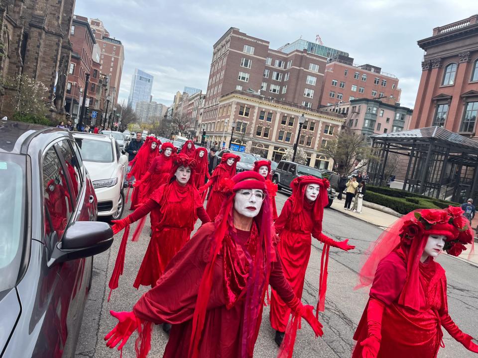 Protesters in "red rebel" costumes march down Newbury Street in Boston as part of a "Funeral for Nature" on April 21.