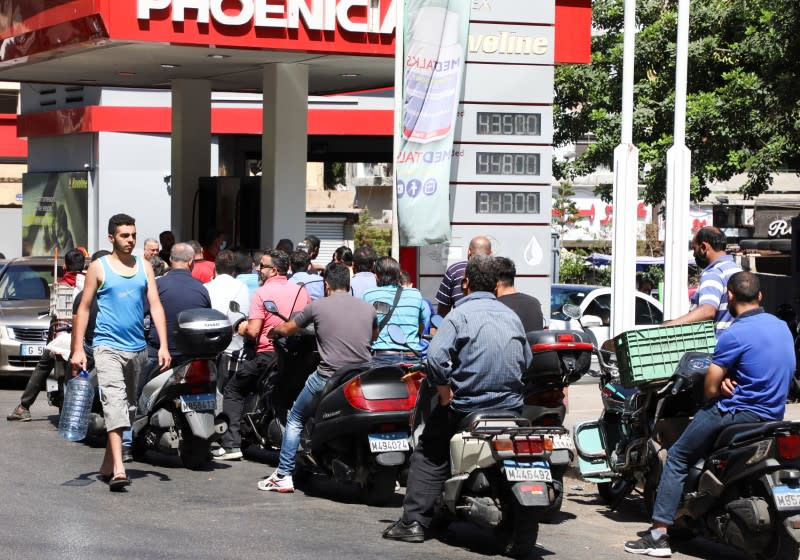 Motorbike riders wait to get fuel at a gas station in Beirut