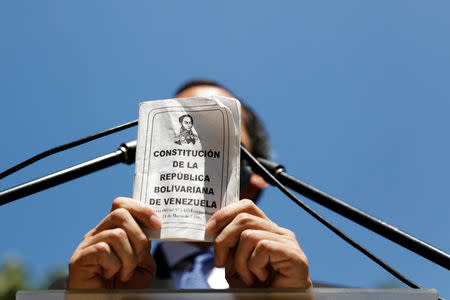 Juan Guaido, President of Venezuela's National Assembly, holds a copy of the National Constitution while he speaks during a news conference in Caracas, Venezuela January 21, 2019. REUTERS/Manaure Quintero