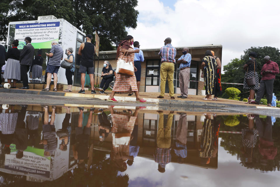 People wait in a queue to get a shot of the sinopharm coronavirus vaccination at Wilkins Hospital in Harare, Wednesday, March, 24, 2021. Zimbabwe is rolling out its COVID-19 inoculation programme and in the first phase is targeting health care workers and the elderly. (AP Photo/Tsvangirayi Mukwazhi)