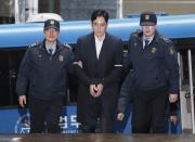 FILE - In this Feb. 22, 2017, file photo, Lee Jae-yong, center, vice chairman of Samsung Electronics Co., arrives at the office of the independent counsel in Seoul, South Korea. Lee was later indicted on bribery charges. A survey by the anti-graft group Transparency International shows that bribery and other forms of corruption are hindering poverty alleviation and hurting public health by channeling resources away from those who need them. The survey, released Tuesday, March 7, 2017, estimated that more than 900 million people in the region had paid bribes in the past year to obtain basic public services like schooling and health care. (AP Photo/Ahn Young-joon, File)