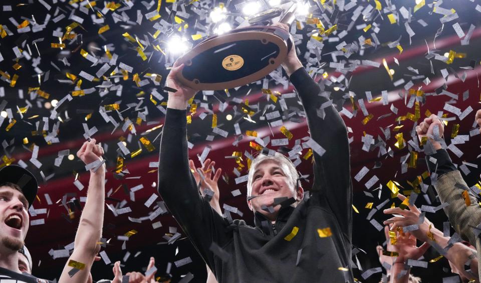 Purdue coach Matt Painter holds up the 2024 NCAA men's tournament Midwest Regional trophy after beating Tennessee at the Little Caesars Arena in Detroit.