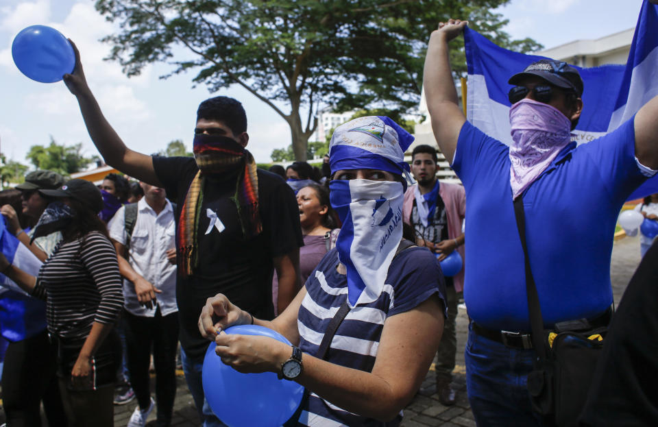Students, many hiding their identify for fear of being identified and later targeted by security forces or government supporters, protest inside the Central American University (UCA) where security forces cannot legally enter, as they demand the release of all political prisoners in Managua, Nicaragua, Tuesday, June 18, 2019, the last day of a 90-day period for releasing such prisoners which was agreed to during negotiations between the government and opposition. Nicaragua's government said Tuesday that it has released all prisoners detained in relation to 2018 anti-government protests, though the opposition maintains that more than 80 people it considers political prisoners are still in custody. (AP Photo/Alfredo Zuniga)