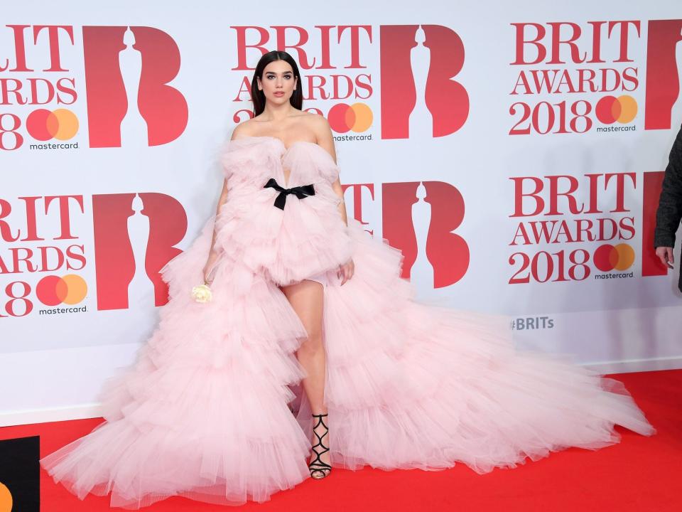 Dua Lipa wears a pink, tulle dress on the red carpet at the 2018 Brit Awards.