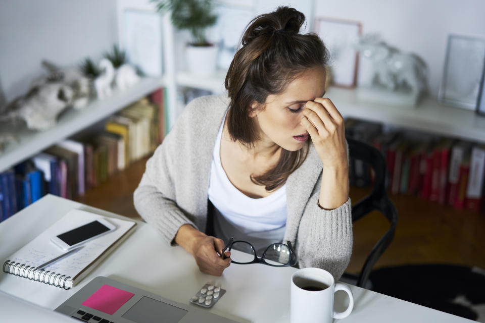 Pictured: Woman with flu in Australia tries to do work while congested. Image: Getty