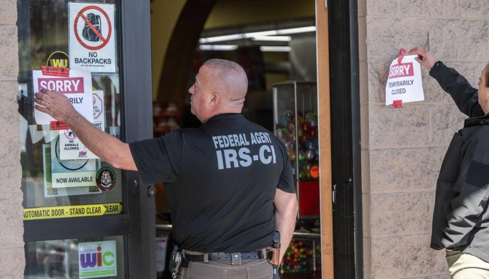 Federal agents remove “temporarily closed” signs at the Viva Supermarket on Folsom Boulevard in Rancho Cordova on Thursday afternoon. The store is owned by Sacramento City Councilman Sean Loloee.