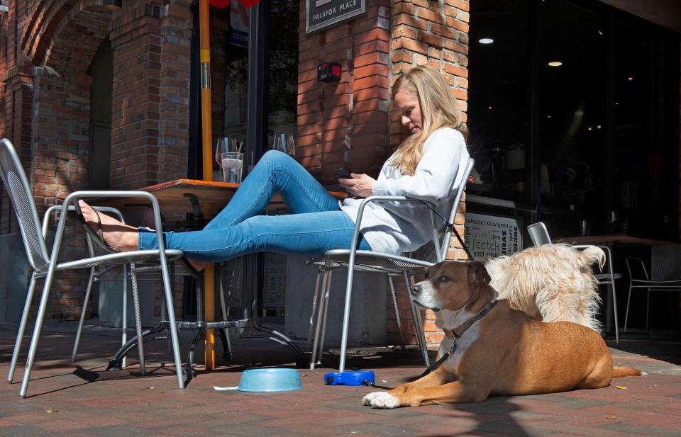 Judy Leeds relaxes with her pets, Bentley and Lucy, at the Wine Bar on Palafox on Friday, Feb. 18, 2022. 