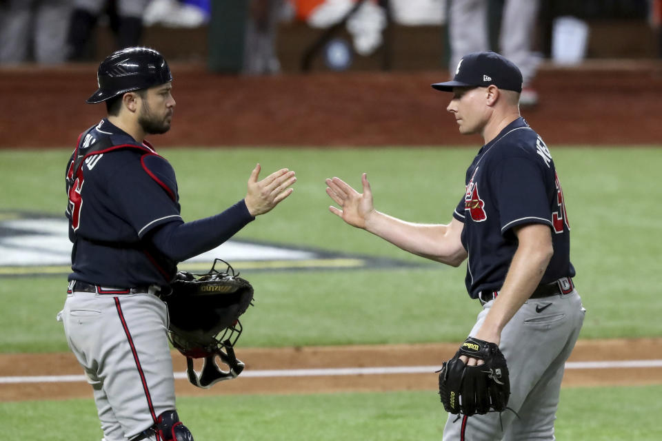 Atlanta Braves relief pitcher Mark Melancon, right, celebrates with catcher Travis d'Arnaud after their win over the Los Angeles Dodgers in Game 2 Tuesday, Oct. 13, 2020, in the best-of-seven National League Championship Series at Globe Life Field in Arlington, Texas. (Curtis Compton/Atlanta Journal-Constitution via AP)