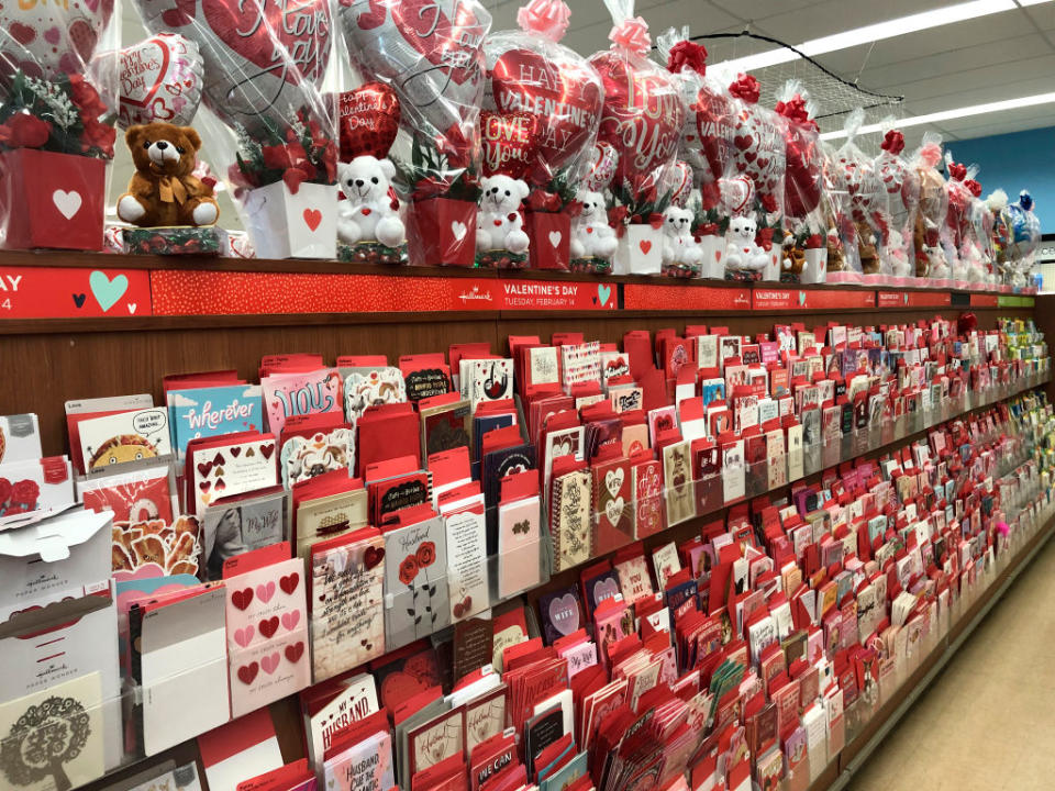 Shelves stocked with various Valentine's Day cards and themed stuffed animals on display in a store