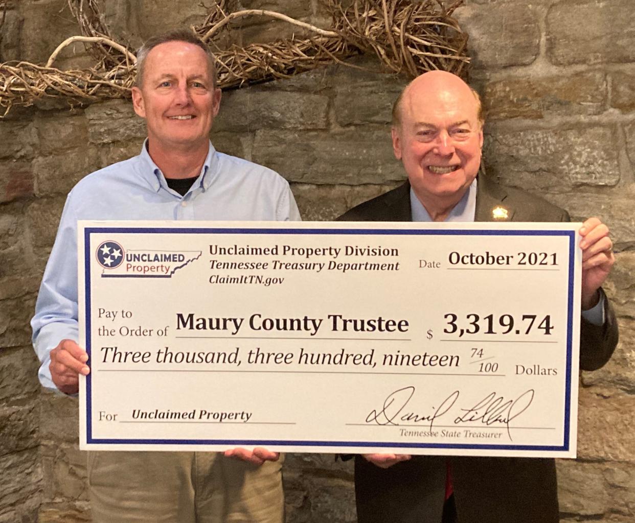 State Treasurer David Lillard, right, presents a check from the Tennessee Department of Treasury for unclaimed property to Trustee Randy McNeece, on behalf of Maury County Government