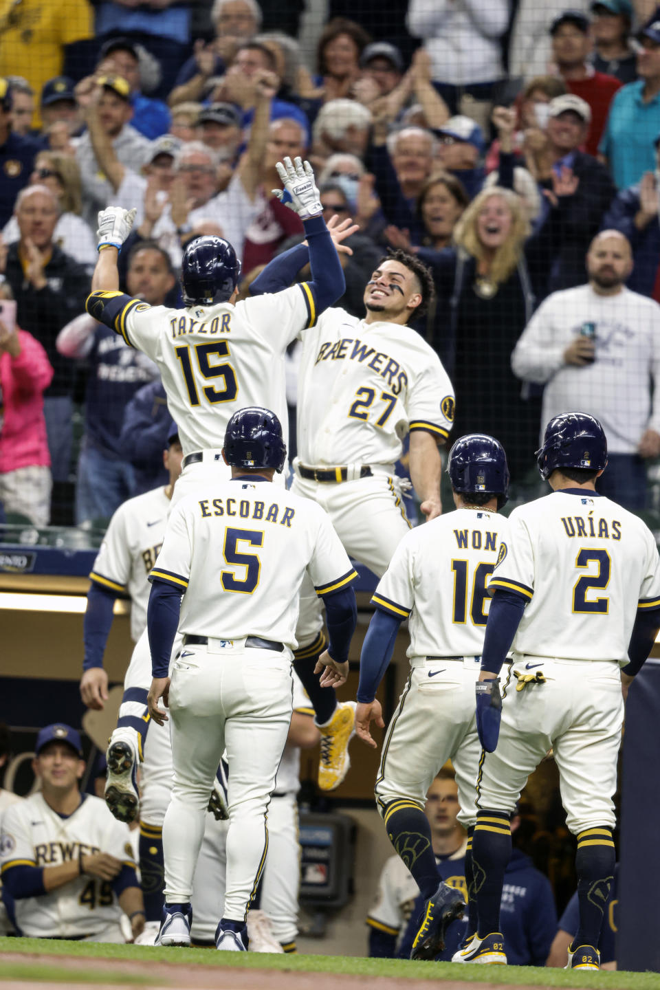 Milwaukee Brewers' Tyrone Taylor(15) gets a high-five from teammate Willy Adames(27) after Taylor's grand slam against the St. Louis Cardinals during the first inning of a baseball game Thursday, Sept. 23, 2021, in Milwaukee. (AP Photo/Jeffrey Phelps)
