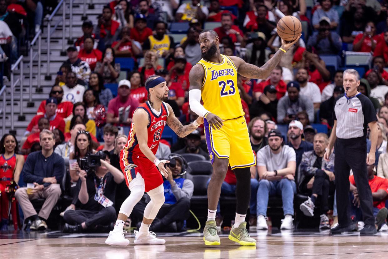 Los Angeles Lakers forward LeBron James looks to pass the ball against New Orleans Pelicans guard Jose Alvarado during the first half of an NBA play-in game at the New Orleans Pelicans, April 16, 2024.