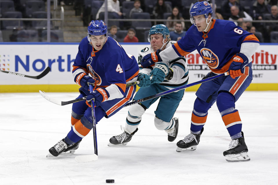 New York Islanders defenseman Samuel Bolduc (4) skates with the puck as Ryan Pulock (6) slows San Jose Sharks left wing Fabian Zetterlund during the first period of an NHL hockey game Tuesday, Dec. 5, 2023, in Elmont, N.Y. (AP Photo/Adam Hunger)