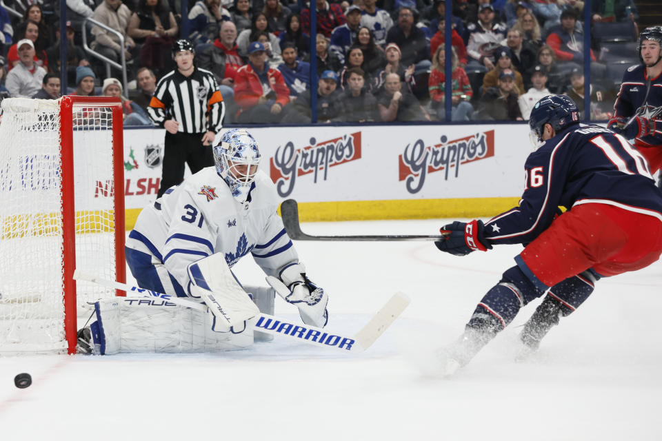 Toronto Maple Leafs' Martin Jones, left, makes a save against Columbus Blue Jackets' Brendan Gaunce during the second period of an NHL hockey game Saturday, Dec. 23, 2023, in Columbus, Ohio. (AP Photo/Jay LaPrete)