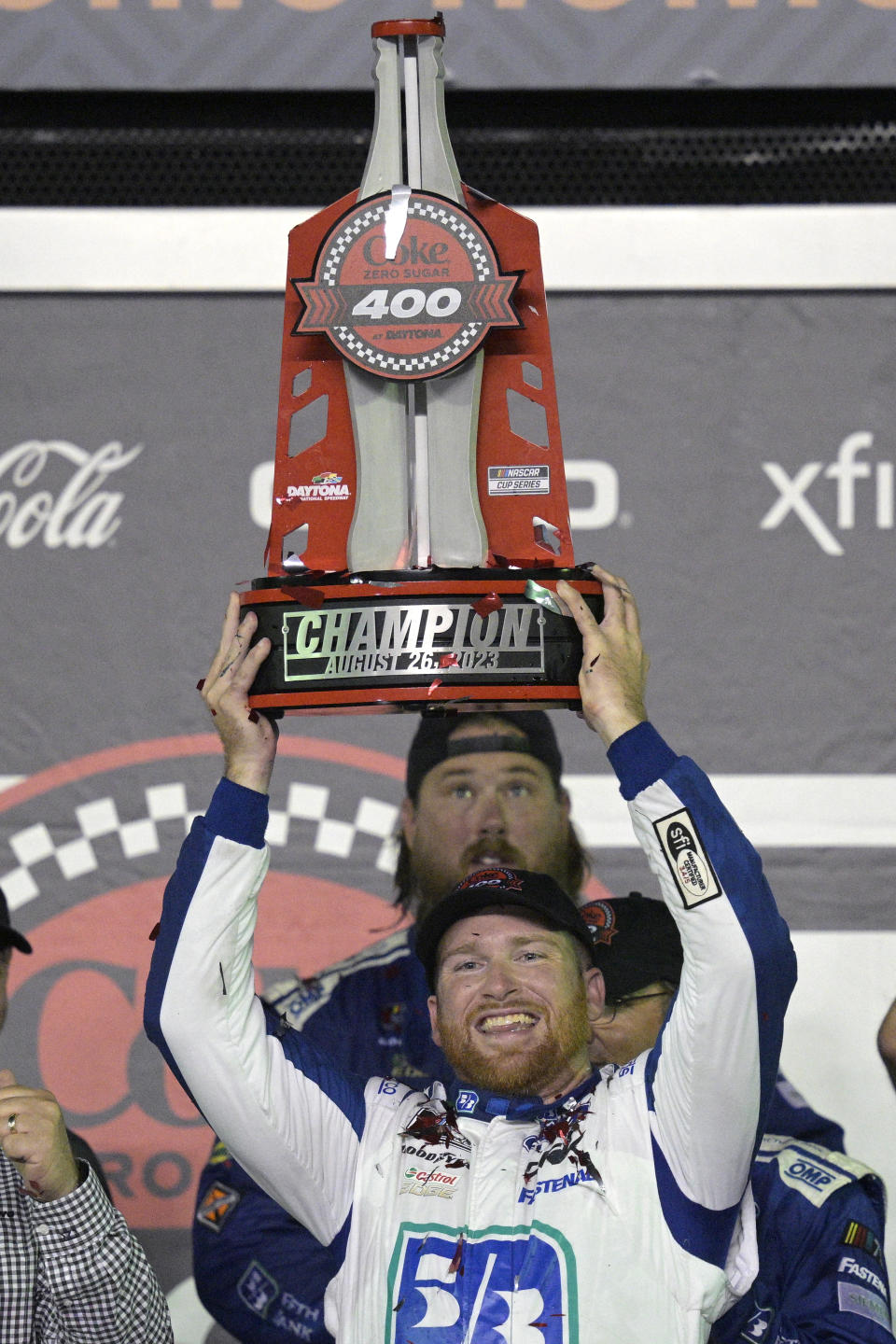 Chris Buescher raises the trophy in Victory Lane after winning the NASCAR Cup Series auto race at Daytona International Speedway, Saturday, Aug. 26, 2023, in Daytona Beach, Fla. (AP Photo/Phelan M. Ebenhack)