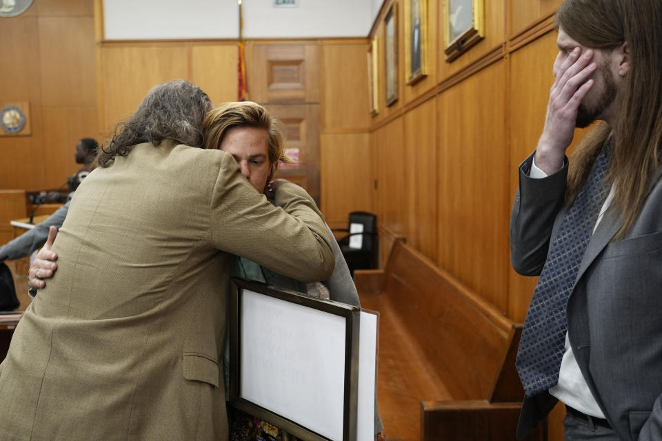 Karissa Bowley, widow of Dau Mabil, a 33-year-old Jackson, Miss., resident who went missing on March 25 and whose body was found in April floating in the Pearl River in Lawrence County, is hugged by her father James E. Bowley, following a hearing on whether a judge should dissolve or modify his injunction preventing the release of Mabil's remains until an independent autopsy could be conducted, Tuesday, April 30, 2024, in Jackson, Miss. (AP Photo/Rogelio V. Solis)