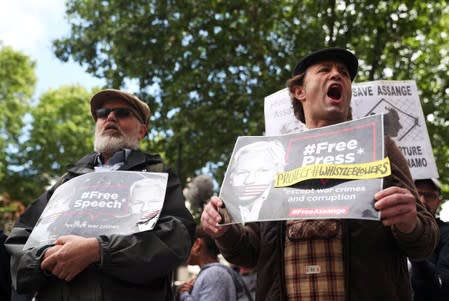 Demonstrators holding placards protest outside of Westminster Magistrates Court, where a case hearing for U.S. extradition of Wikileaks founder Julian Assange is held, in London