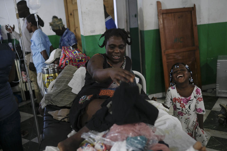 Younaika laughs next to her mother Jertha Ylet who was injured in the 7.2 magnitude earthquake one week prior, at the Immaculate Conception Hospital, also known as the General Hospital of Les Cayes, Haiti, Sunday, Aug. 22, 2021. Her 5-year-old daughter, who was not injured, shares her bed, and they have no home to return to, after the quake brought down their house in Camp-Perrin, killed her father and two other relatives and seriously injured her brother. (AP Photo/Matias Delacroix)