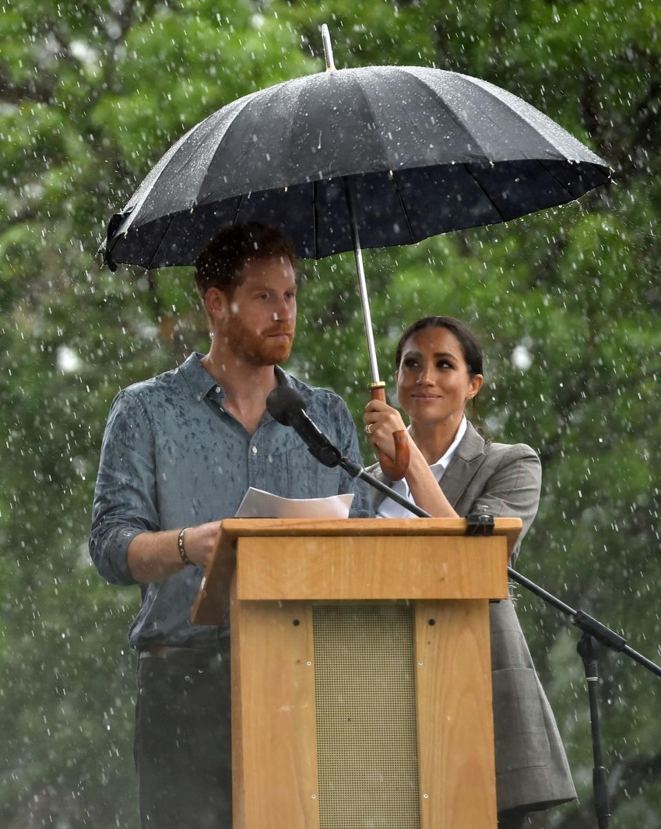 <p><strong>17 October </strong>The Duchess of Sussex shelters her husband while he delivered a speech in Dubbo, in which he commended resilient farmers for persisting through years-long dry spells.</p>