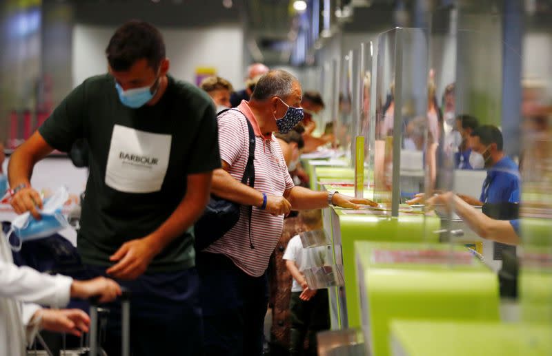British tourists returning to UK, check in their luggage, as Britain imposed a two-week quarantine on all travellers arriving from Spain