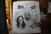 An Indian artist Aejaz Saiyed gives finishing touch to an art work featuring U.S.President-elect Joe Biden, Vice President-elect Kamala Harris and Indian freedom fighter Mahatma Gandhi, ahead of Biden's inauguration ceremony, in Ahmedabad, India, Wednesday, Jan. 20, 2021. The inauguration of Biden and Harris is scheduled be held Wednesday. (AP Photo/Ajit Solanki)